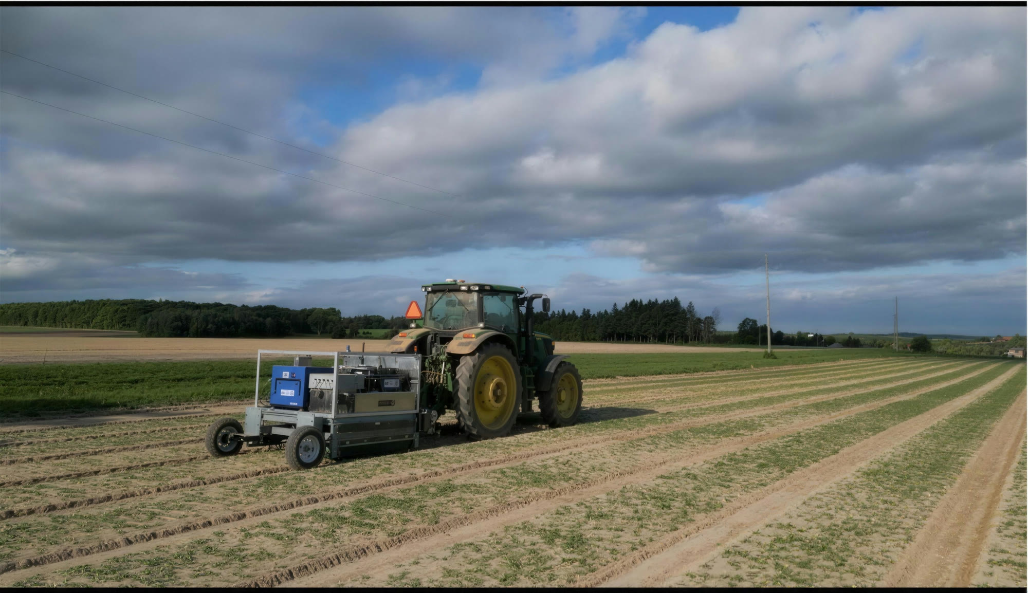 Tractor towing the Clean Works in-field treatment system along crop rows