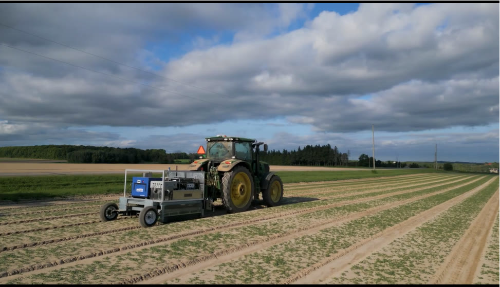 Tractor towing the Clean Works in-field treatment system along crop rows